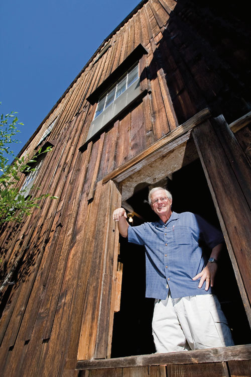 Bob Russell standing in the window of the Butte Creek Mill. Photo by Jamie Lusch, courtesy of Oregon Business Magazine.