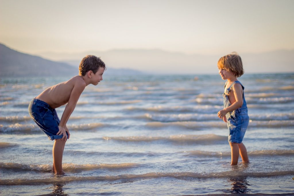 10 tips for traveling solo with kids. Photo of two children at the beach, courtesy of Limor Zellermayer, via Unsplash. | Jennifer Margulis