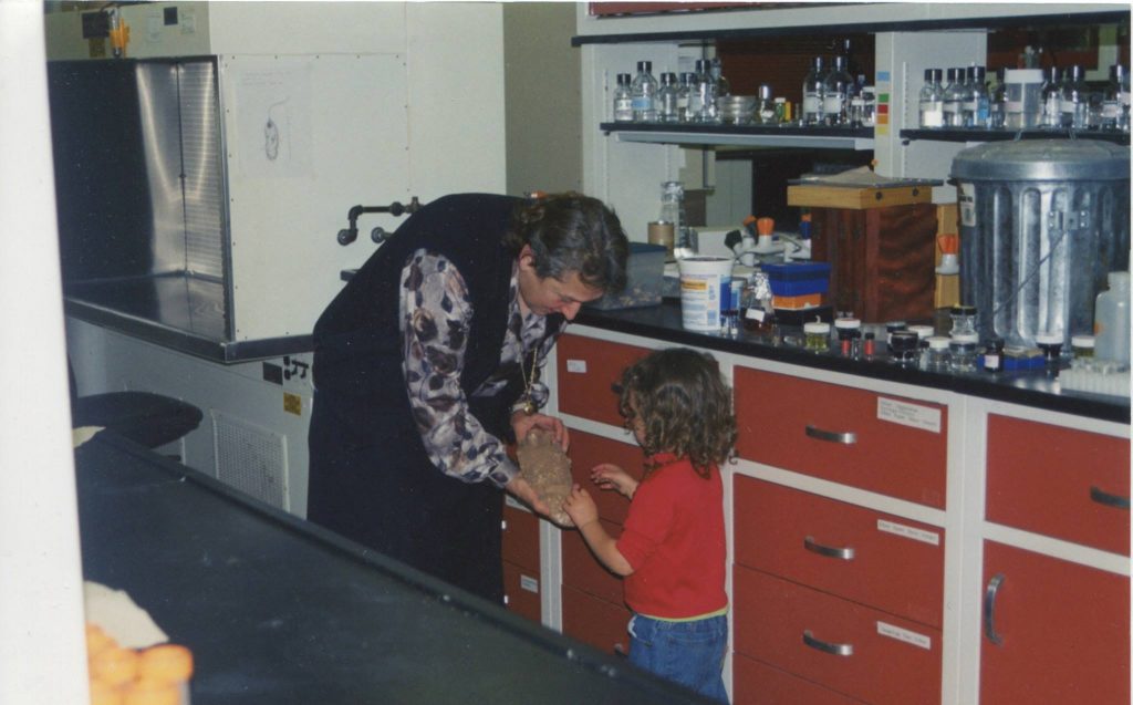 Evolutionary biologist Lynn Margulis, Ph.D., showing a fossil to her granddaughter at her laboratory at University of Massachusetts, Amherst. Be extra kind to your mom, she could die suddenly. Photo credit: Jennifer Margulis. 