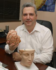 M.D./Ph.D. researcher Manuel Casanova has concerns about ultrasound safety when used during pregnancy. Photo of him holding a human brain. Via Jennifer Margulis.