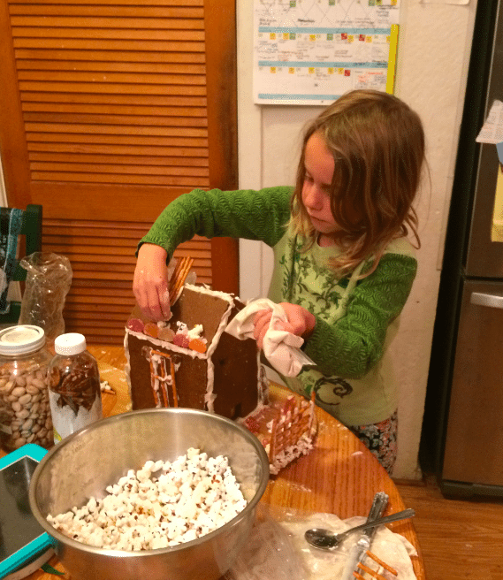 Using royal icing as glue to decorate a whole grain gingerbread house. Photo credit: Jennifer Margulis.