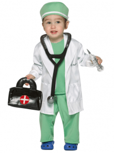 A toddler dressed as a doctor holding a medical bag and a vaccine. Many doctors in America are concerned we are giving too many vaccines too soon.